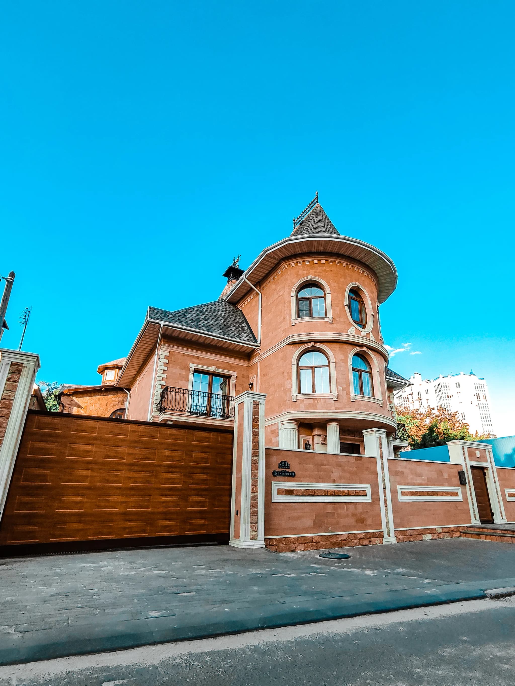 Large house with a warm terracotta-coloured exterior and a round corner turret