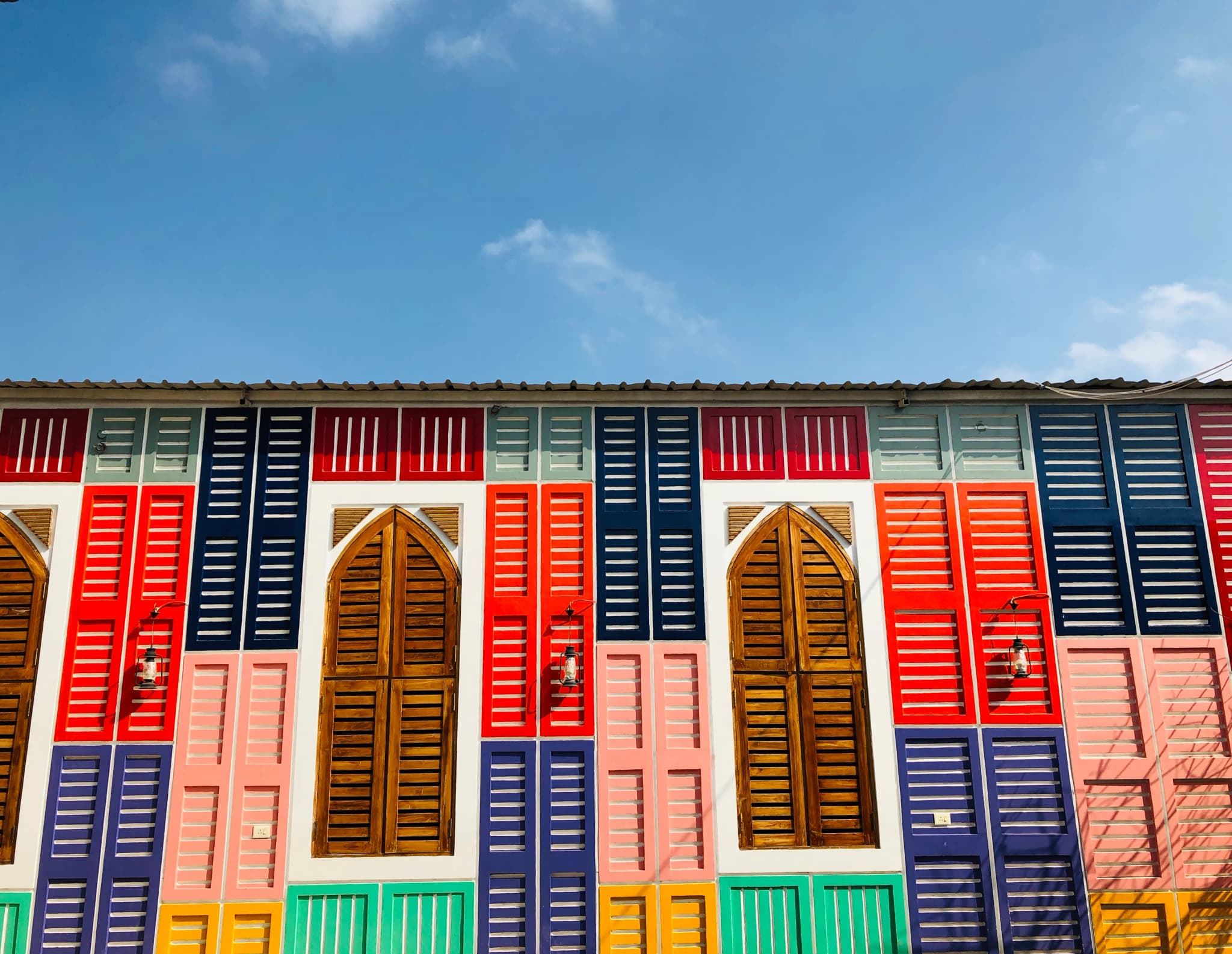 Building front with rows of red, blue, green and yellow window shutters