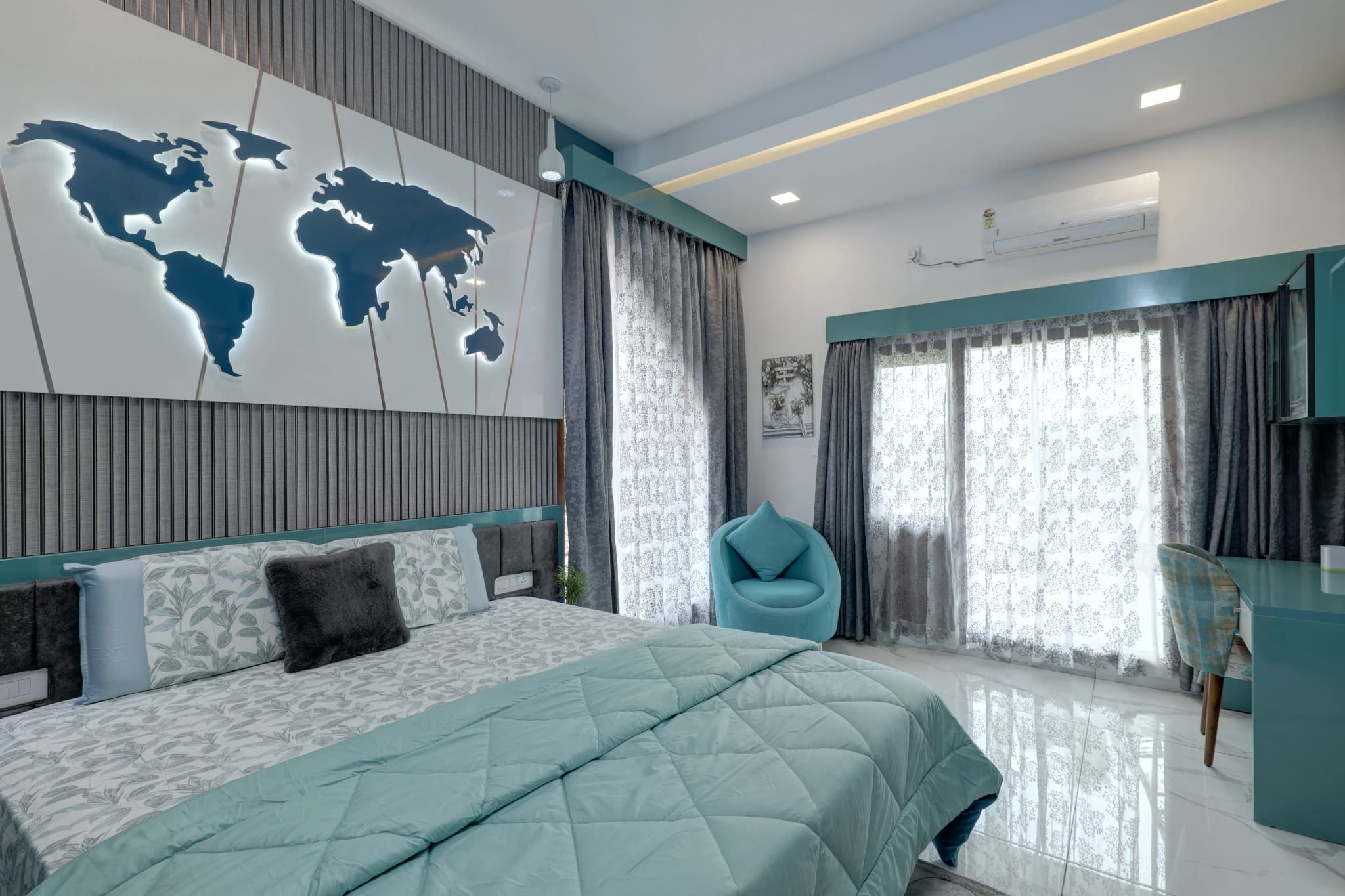 Bedroom with grey and teal accents, a world map on the headboard wall and sheer curtains