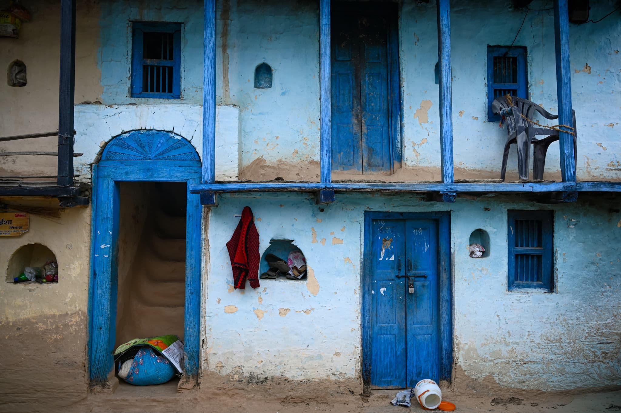 Village house with pale blue walls and dark blue doors and window frames