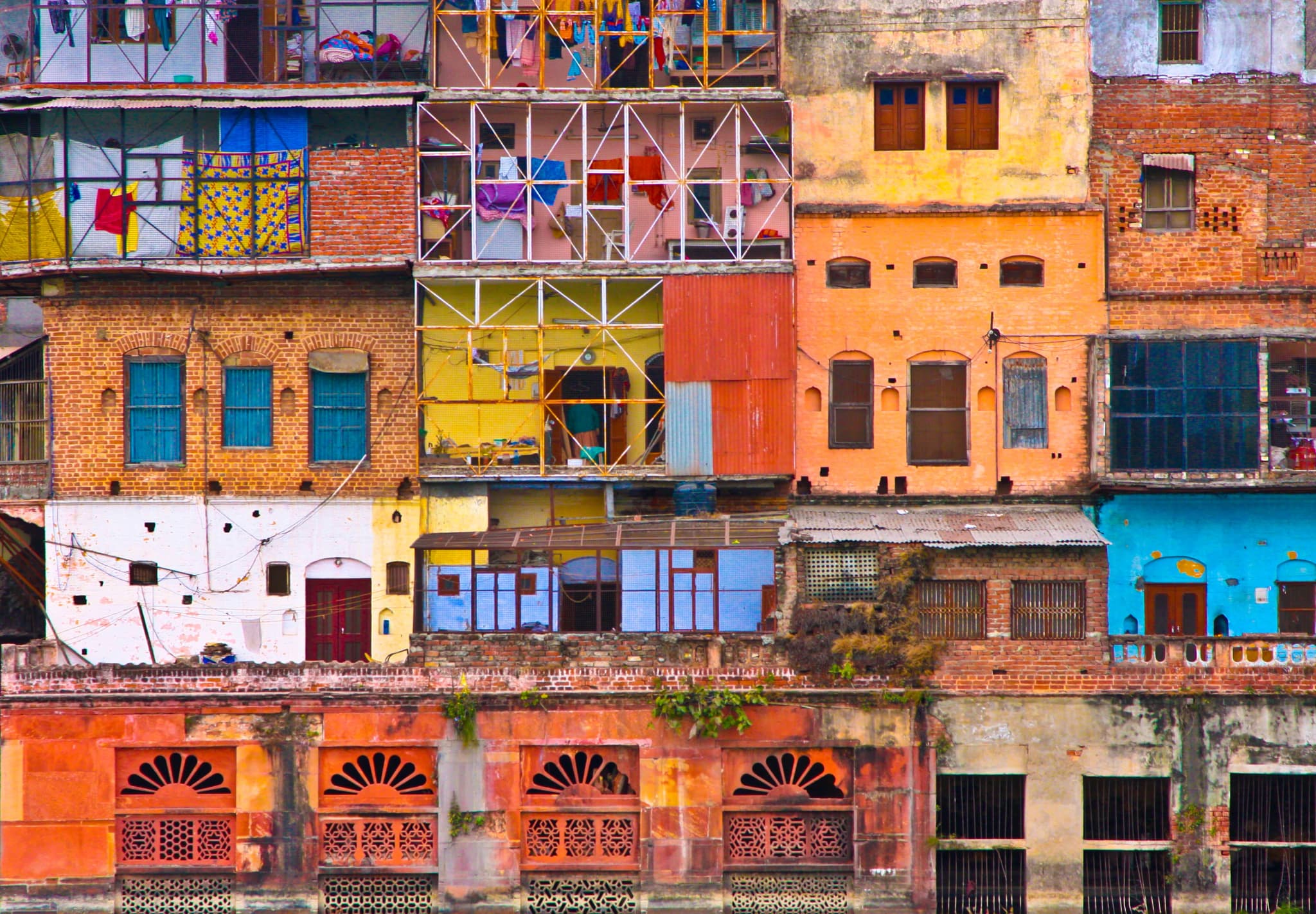 Old city buildings painted orange, yellow, blue and white, packed side by side