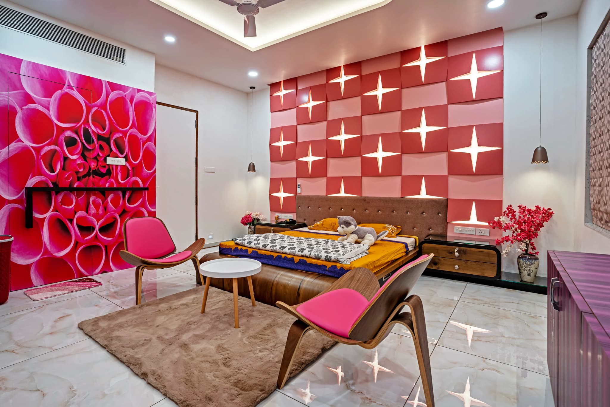 Bedroom with a red tiled feature wall, a large flower mural, pink chairs and a wooden bed
