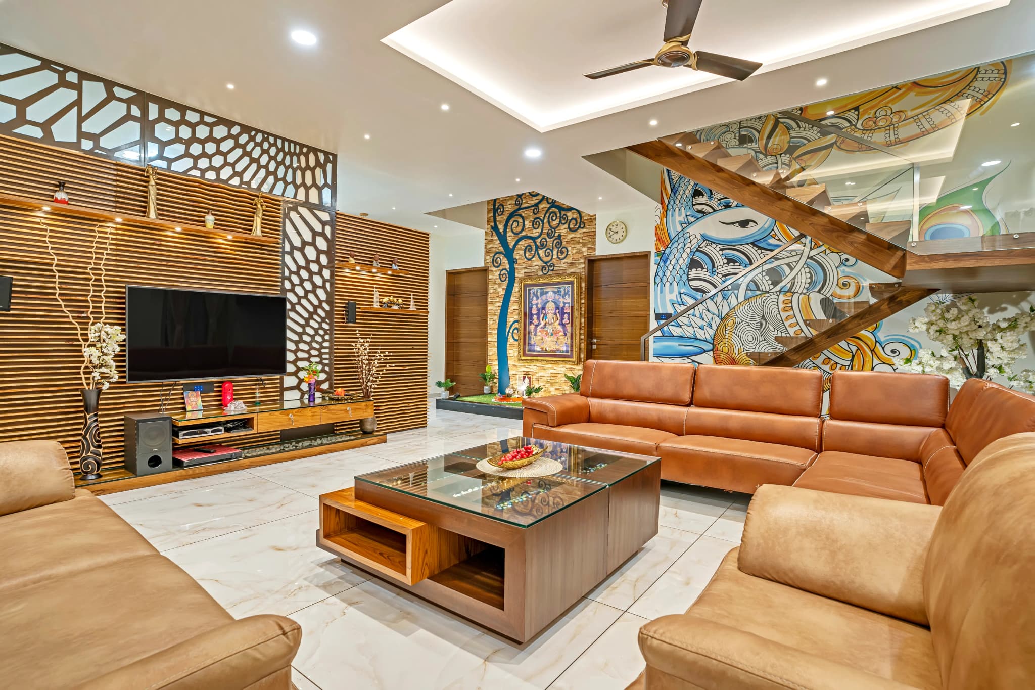 Living room with a carved wooden screen, a mural wall, tan leather sofas and a wooden coffee table