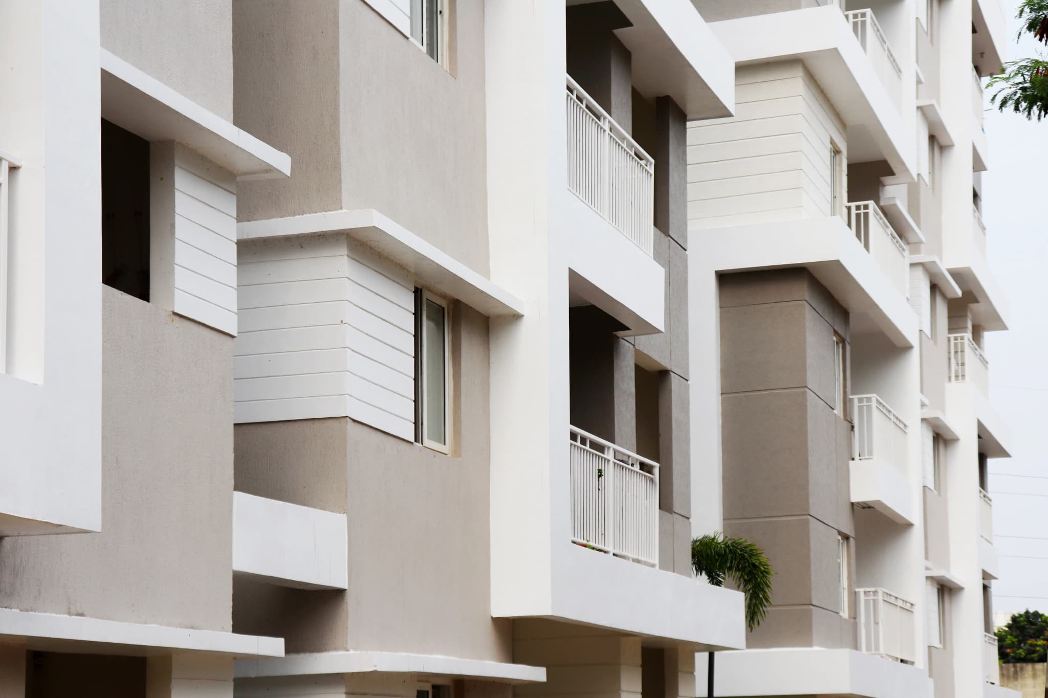 White apartment building with grey bands and balconies